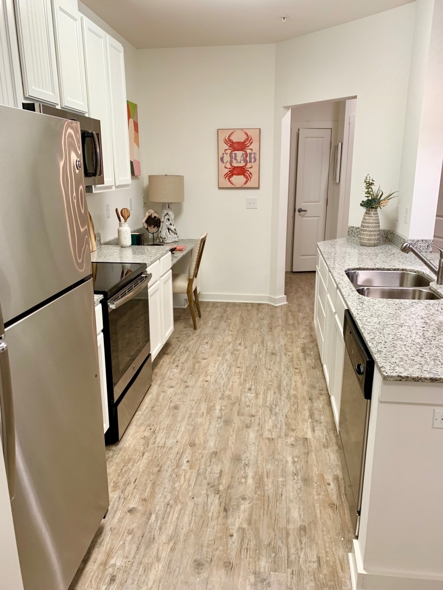 A kitchen with white cabinets, granite counter tops, and Your Two Bedroom Apartment.