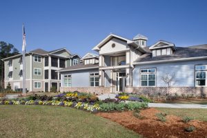 A spacious house adorned with a vibrant lawn and beautiful flowers.