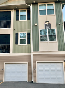 A two story apartment building with garages and balconies offering apartments with garages.