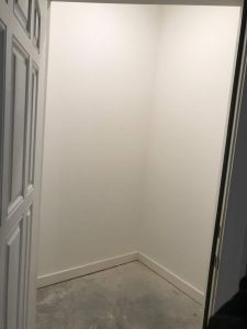 A vacant space with a door entrance.