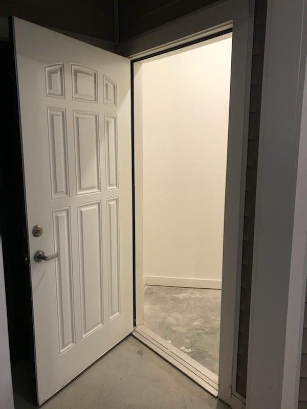 A white door is open to an apartment.