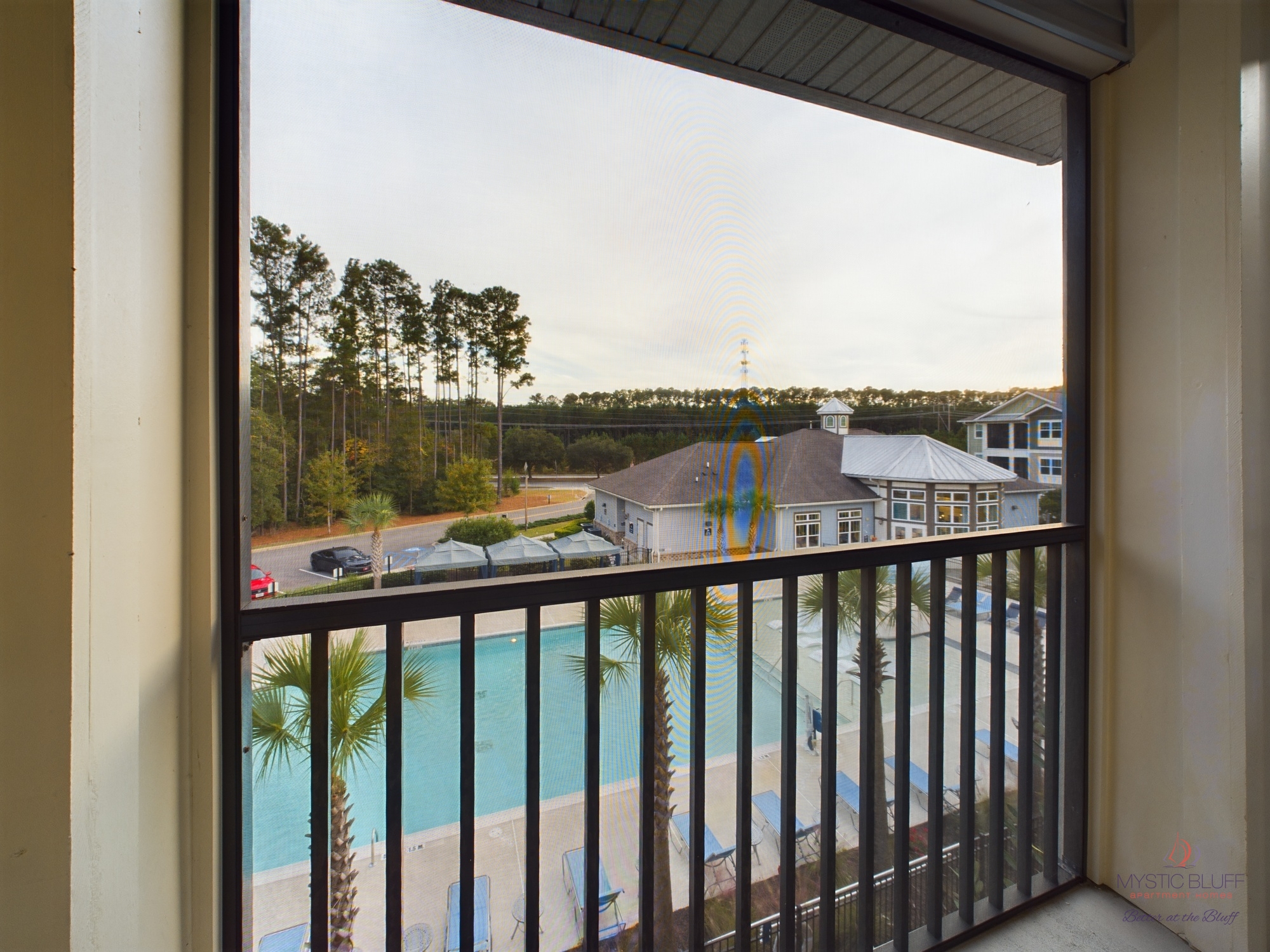 A view of a pool from a balcony in one bedroom apartments.