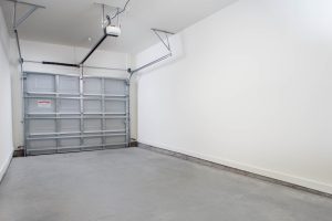 Apartments in Bluffton A clean, empty garage with a closed garage door, white walls, and a concrete floor.