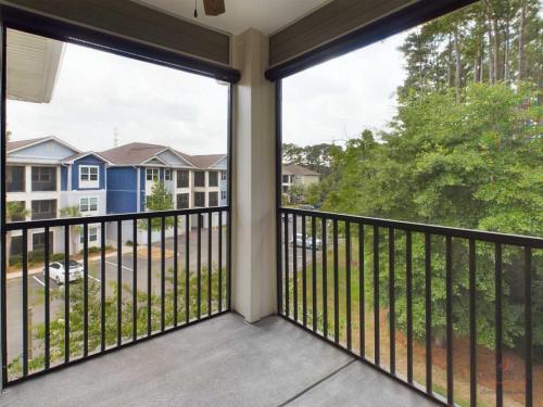 Apartments in Bluffton Screened balcony overlooking a parking lot and a view of nearby trees and apartment buildings.